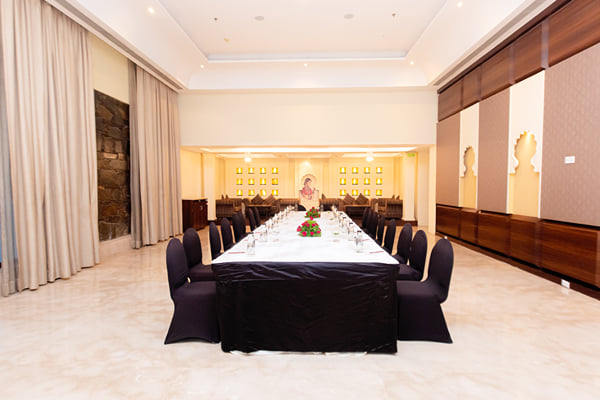 Zuma hall: meeting room with long dressed table, black chairs and curtained windows