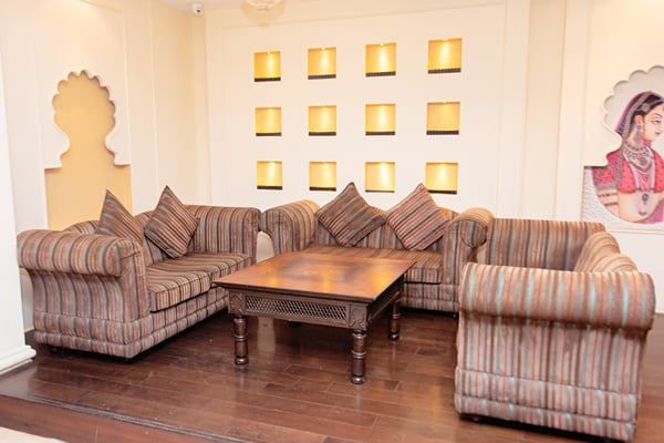 Zuma hall: striped sofas and armchair around coffee table with wall niches and painting