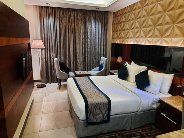 Suite with king bed and living space at RG Royal Hotel & Convention, Bengaluru