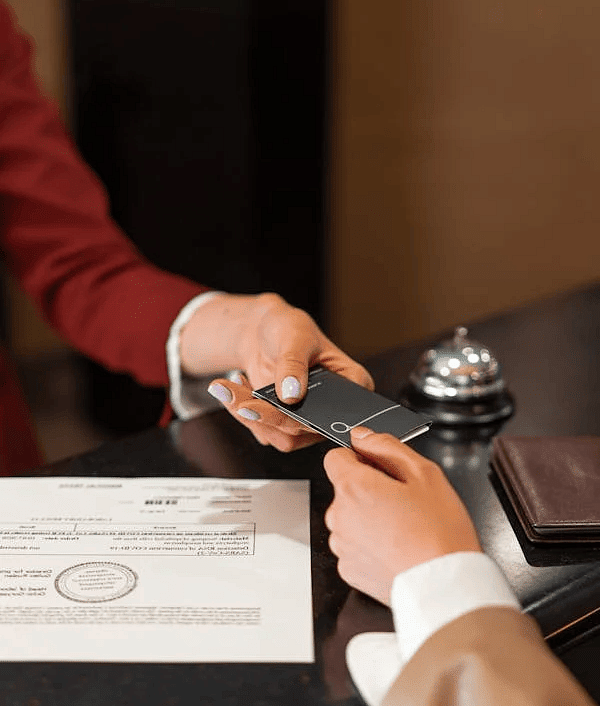 A hand handing out a card to another person