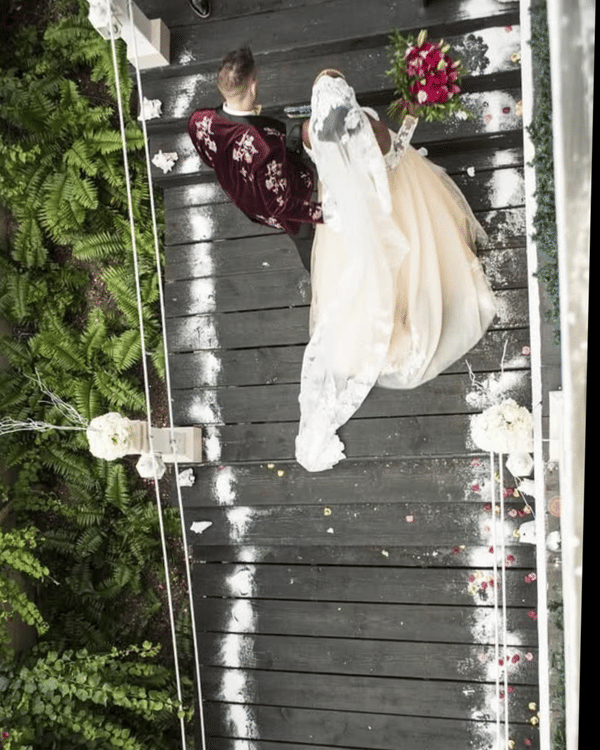 Aerial view of a bride and groom walking a petal-strewn aisle at A Stone's Throw Away