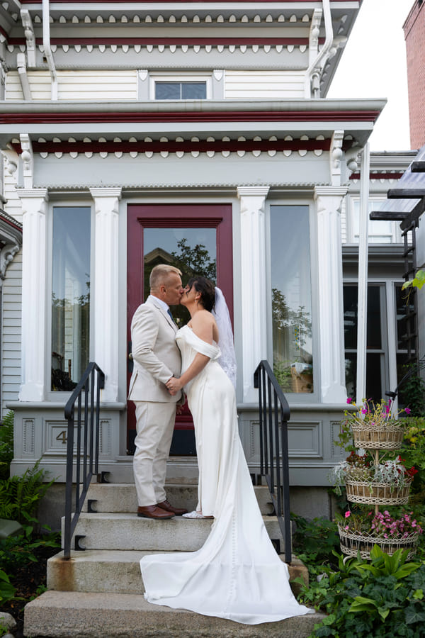 A couple kissing on the front steps of Hartstone Inn