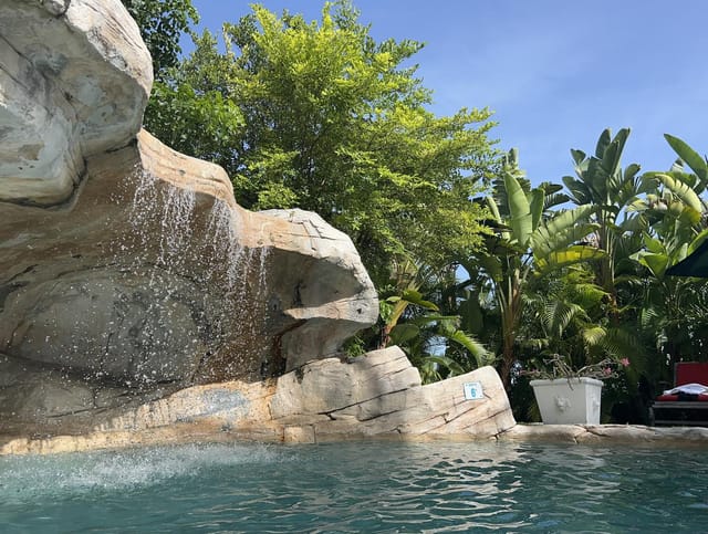 The pool with its rock waterfall and tropical planting at A Stone's Throw Away