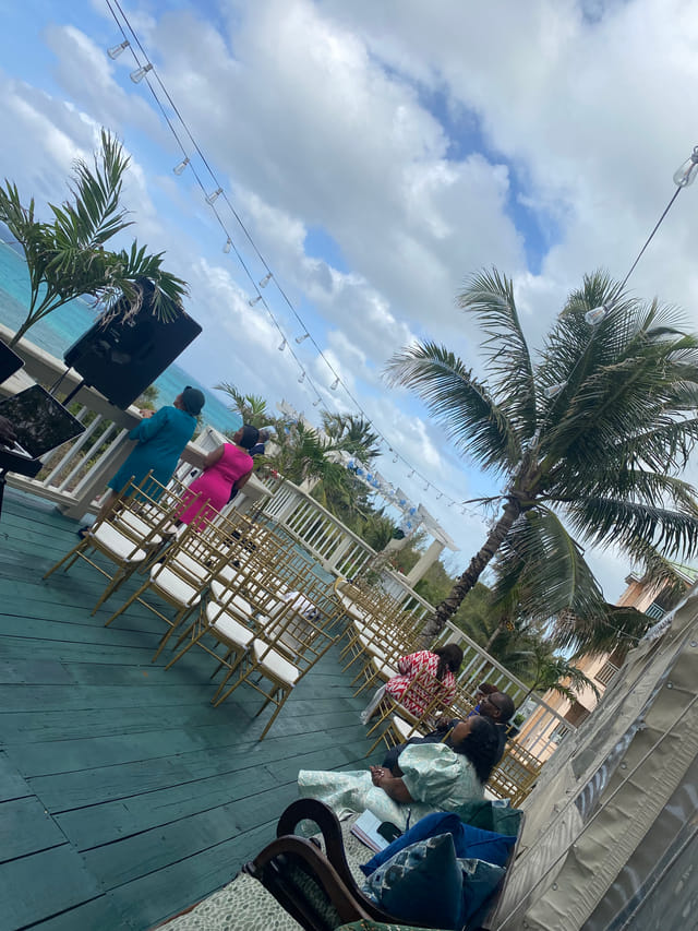 Ceremony seating on the ocean-view patio with string lights and palms at A Stone's Throw Away