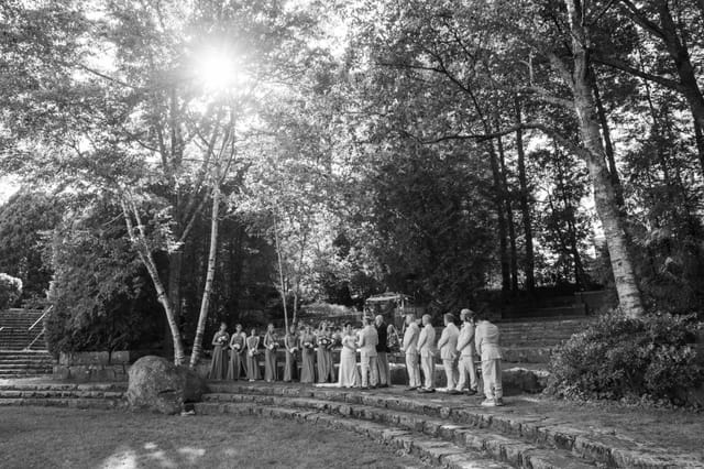 A wedding ceremony on the stone garden terrace beneath birch trees at Hartstone Inn