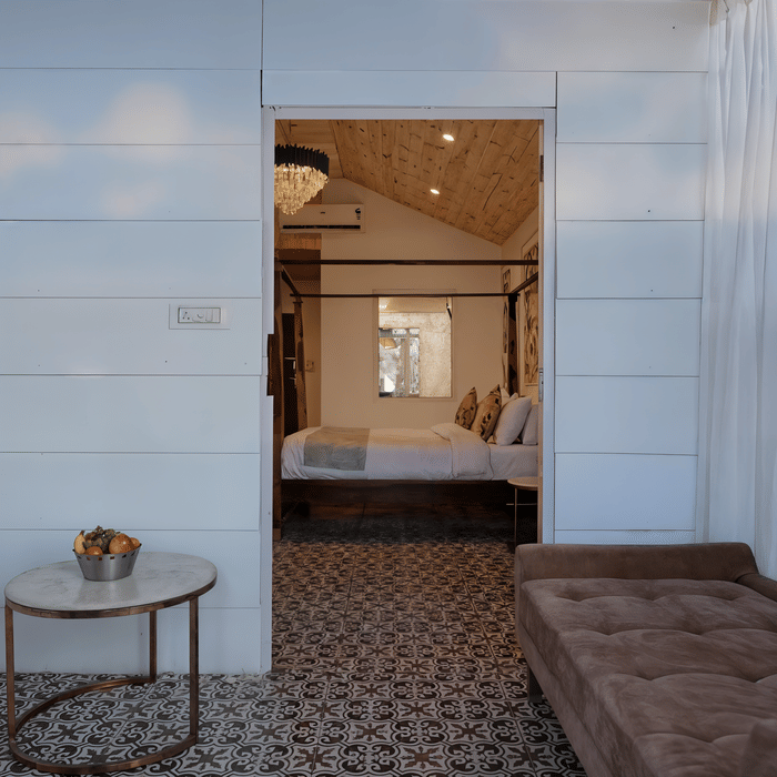 Timber flooring and soft seating in the living area of a Luxe Cottage room at Nazaara Nature Retreat, Dalhousie.