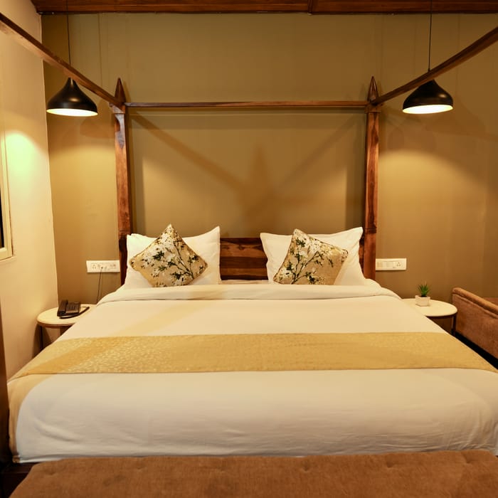 Gallery photo of the Luxurious Cottage king bed at Nazaara Nature Retreat, styled with white linen against a wood headboard