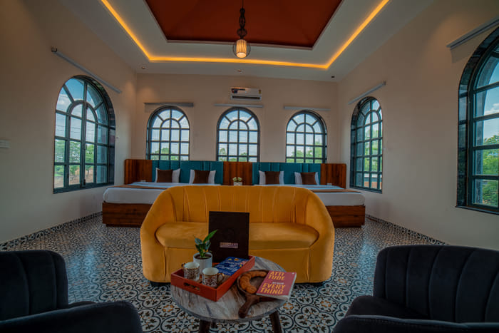 Nazaara Family Suite at Nazaara Hills Retreat, Udaipur, twin beds beside a lounge seating area.