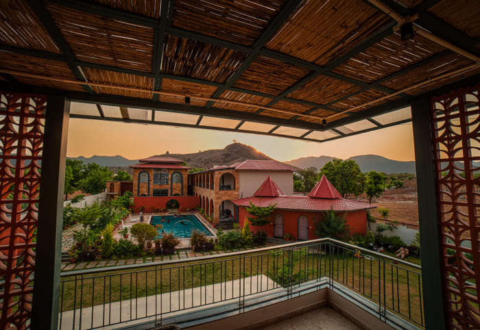 Nazaara Hills Retreat, Udaipur, elevated pool view at sunset
