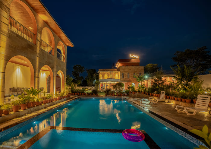 Nazaara Hills Retreat, Udaipur, pool courtyard view with arched building