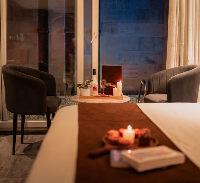Seating nook with drinks set out beside the private pool of the Premium Plunge Pool Room at Nazaara Hills Retreat, Udaipur.