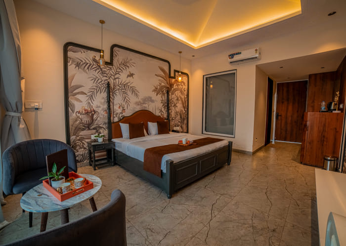 Interior of the Superior Room at Nazaara Hills Retreat, Udaipur, showing the seating and dining area.