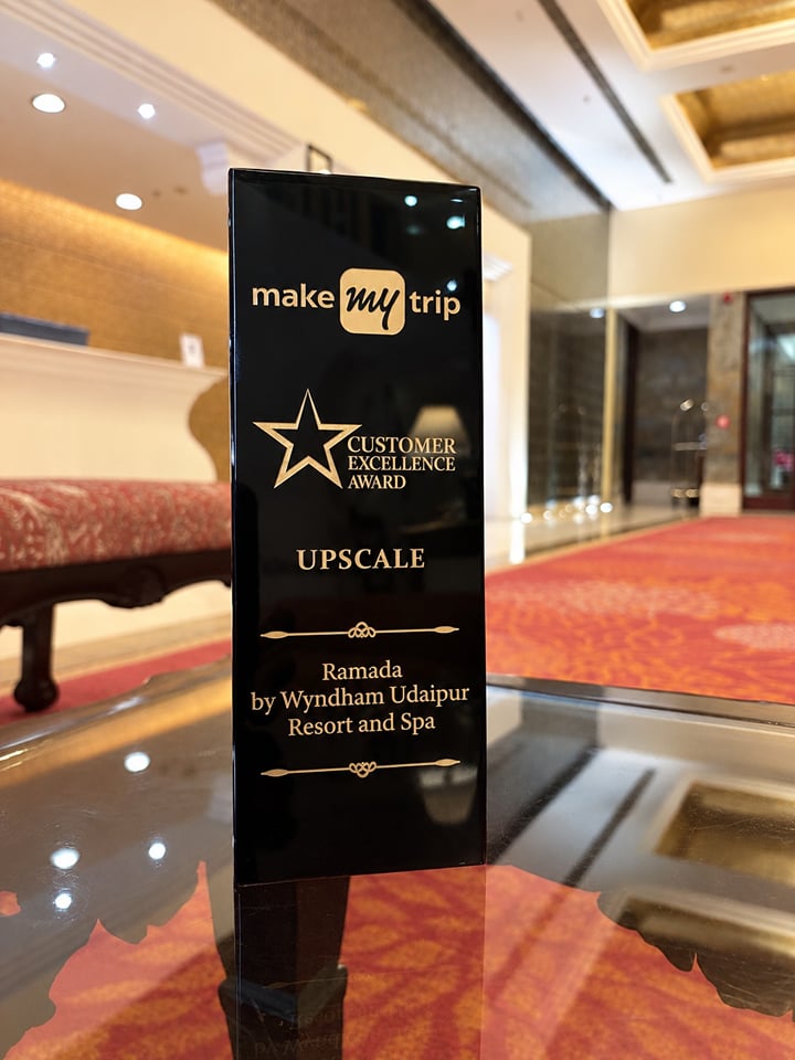 MakeMyTrip Customer Excellence Award trophy for Ramada by Wyndham Udaipur Resort and Spa, standing in the resort lobby