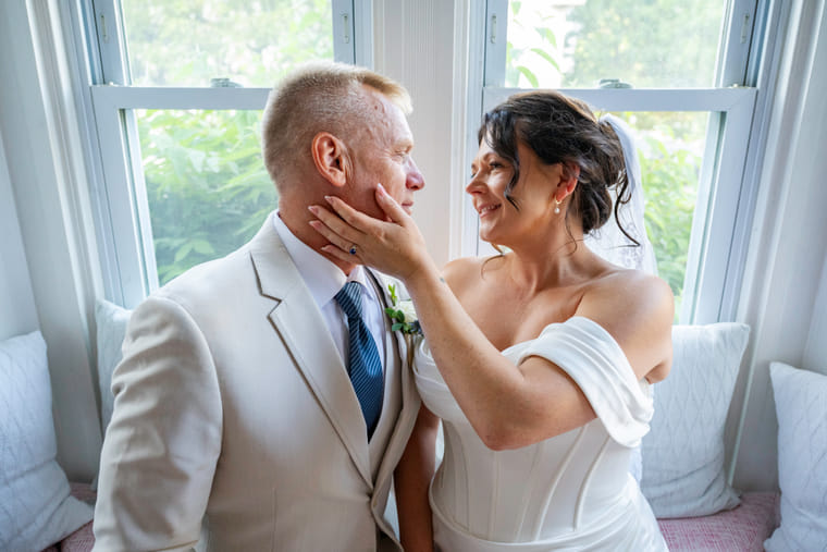 A bride and groom sharing a quiet moment on the window seat at Hartstone Inn