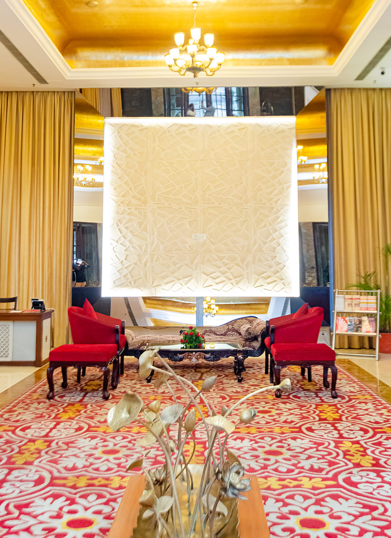 Lobby seating with a carved panel at Ramada by Wyndham Udaipur Resort and Spa