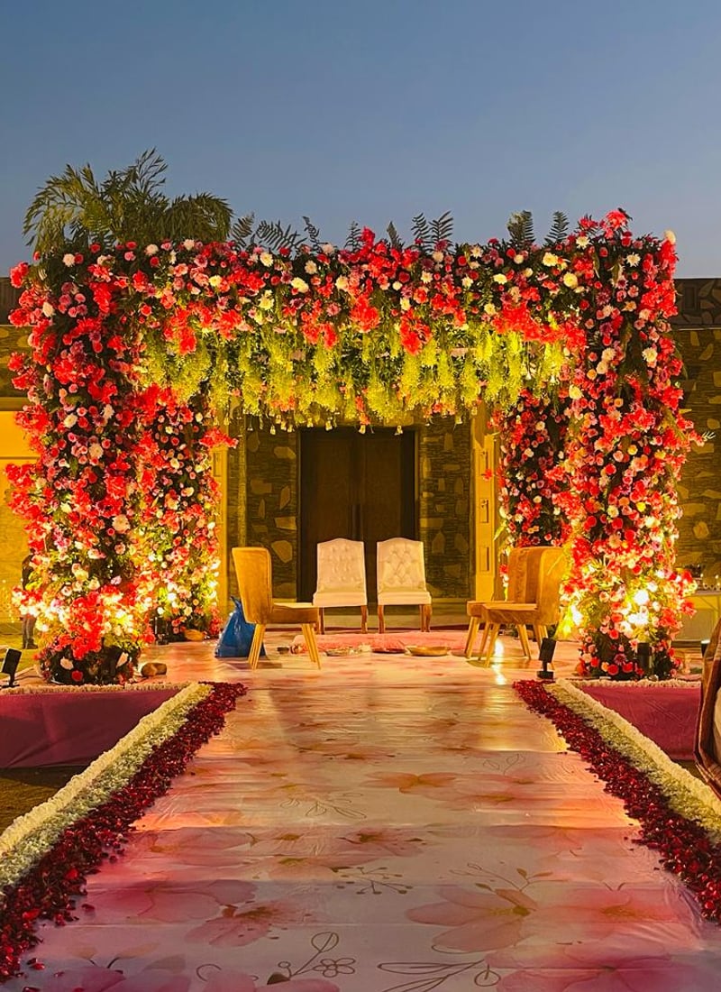 Flower-decorated gateway and aisle at dusk at Ramada by Wyndham Udaipur Resort and Spa