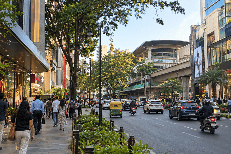 Shopfronts, traffic, and the elevated metro line along MG Road