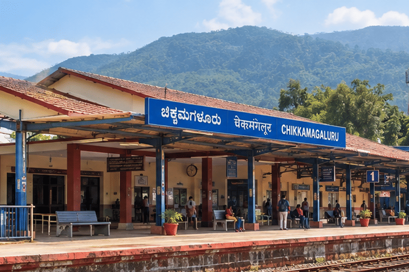 Chikkamagaluru railway station platform with its blue name board and green hills behind