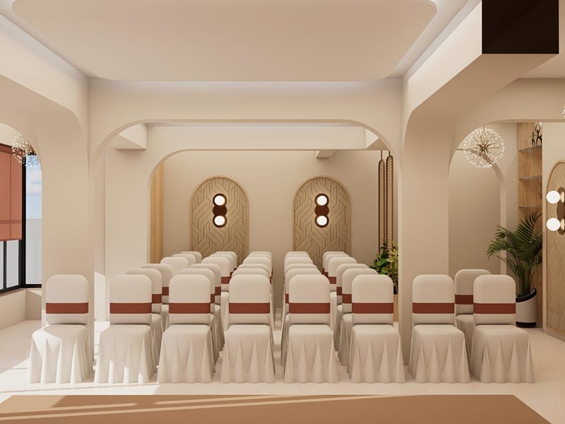 Open banquet area with a raised stage end and patterned flooring | Shirgaonkar Beach Resort