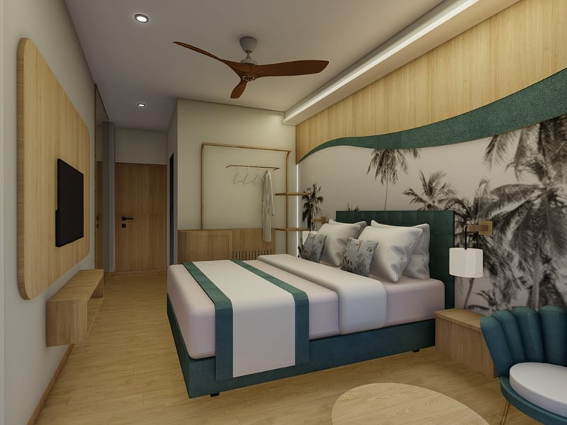 Deluxe Room with a wall-mounted television on a wood panel and a fluted teal armchair | Shirgaonkar Beach Resort