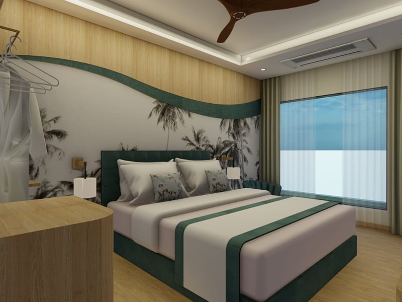 King bed with a green upholstered headboard against a palm-print mural in a Deluxe Room | Shirgaonkar Beach Resort