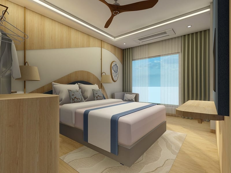 Sea View Room with a king bed facing tall windows and a grey sofa in the corner | Shirgaonkar Beach Resort