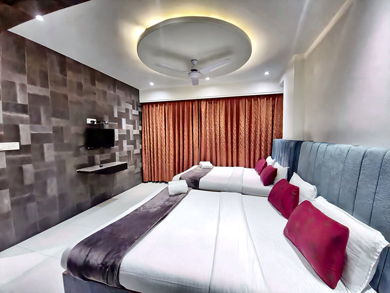 Presidential Suite beds facing a wall-mounted TV