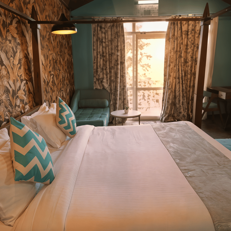 Four-poster bed with botanical-print headboard panels in a guest room at Nazaara Nature Retreat, Dalhousie