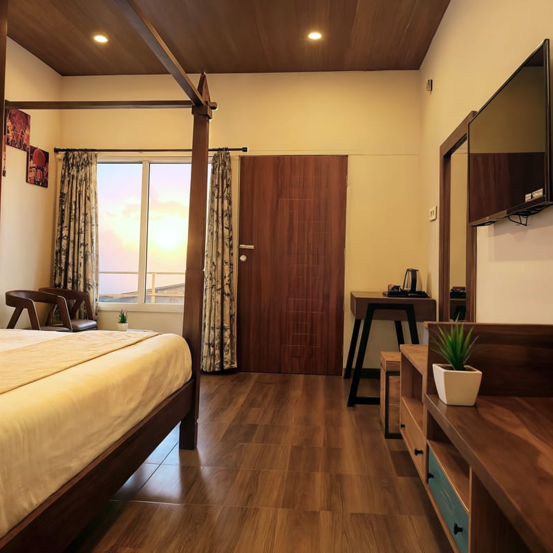 Superior Room amenities at Nazaara Nature Retreat featuring a tea and coffee tray, folded towels, and a bedside reading lamp