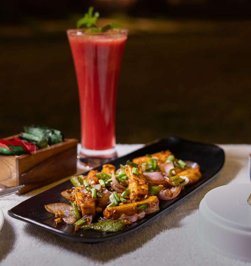 Chilli paneer served alongside a watermelon juice at Nazaara Fine Dine, Nazaara Hills Retreat, Udaipur.