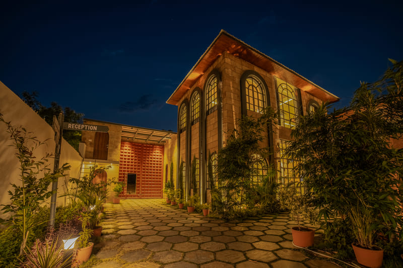 The entrance facade and reception signage at Nazaara Hills Retreat, Udaipur, pictured from the driveway.