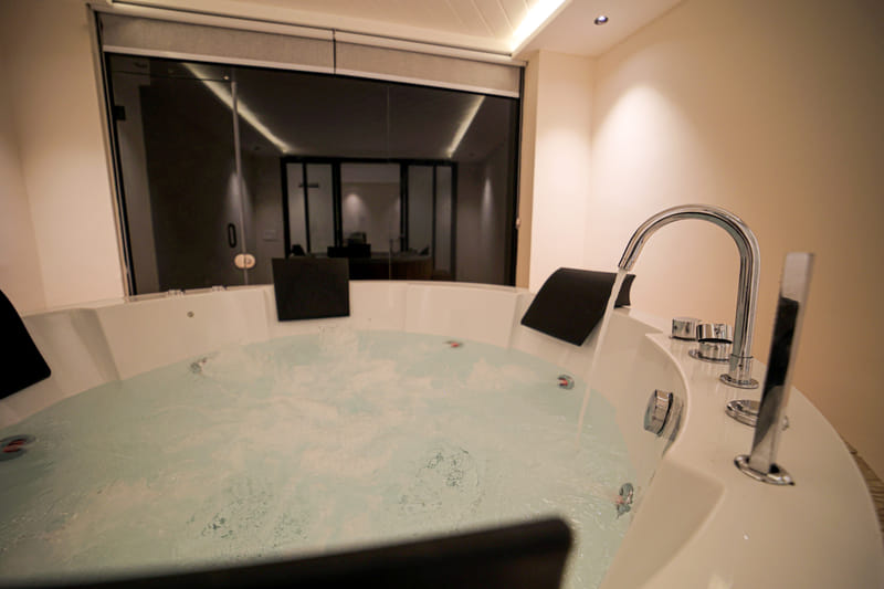 Close-up of the dual chrome taps on a private Jacuzzi tub at Nazaara Hills Retreat, Udaipur.