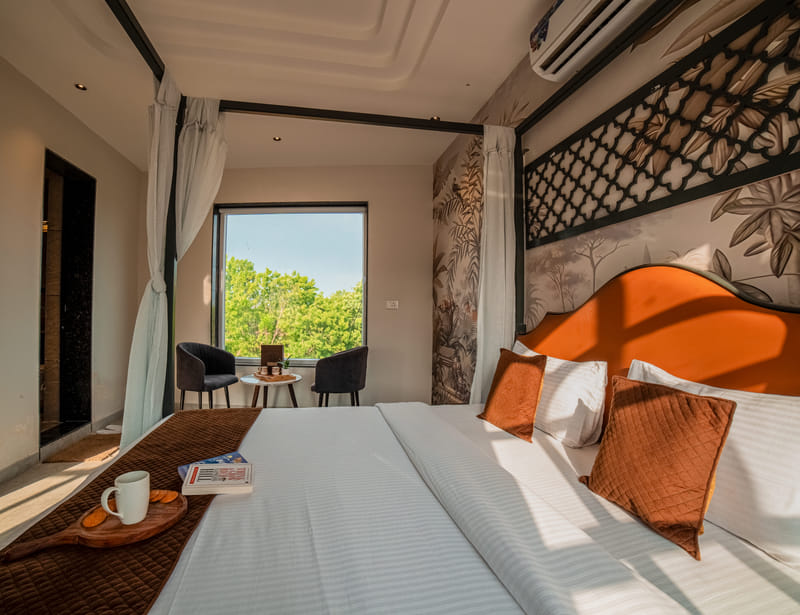 The canopy bed and window seating nook in the Nazaara Royal Suite at Nazaara Hills Retreat, Udaipur.