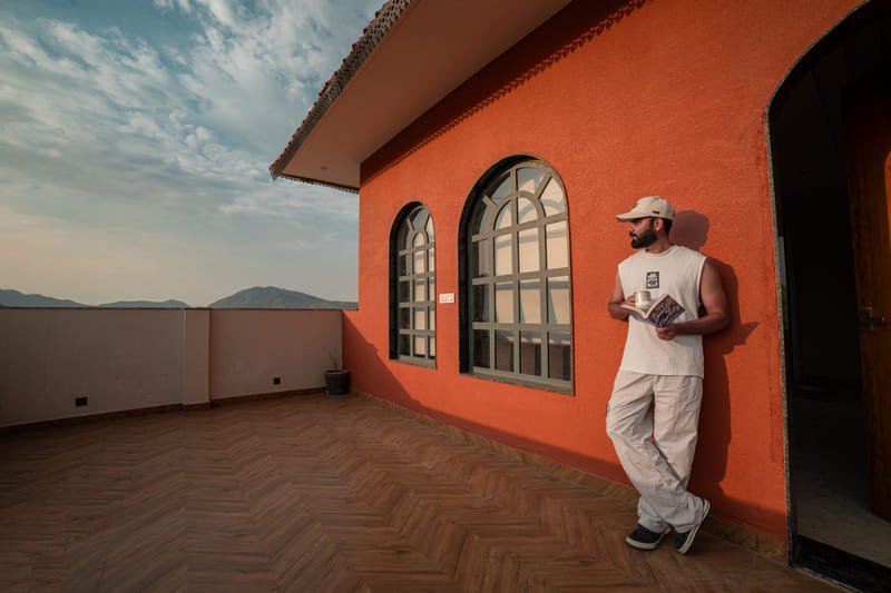 A guest reading on the private terrace balcony of the Nazaara Royal Suite at Nazaara Hills Retreat, Udaipur.