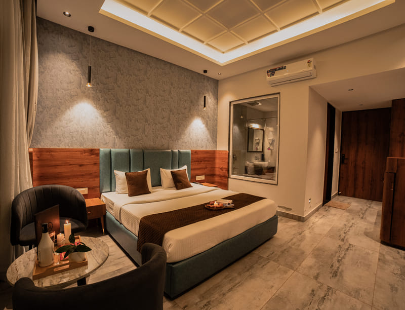 The Premium Plunge Pool Room bed with a view through to the glass-walled bathroom, Nazaara Hills Retreat, Udaipur.