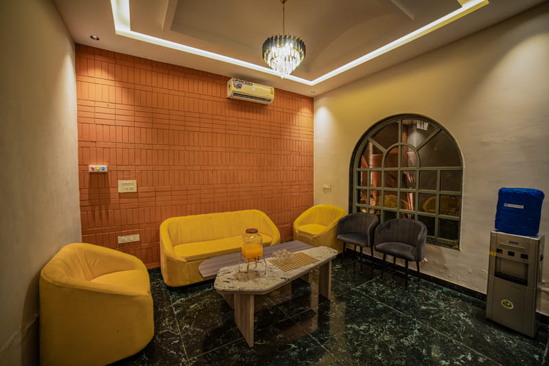 A juice and water dispenser set up in the reception lounge at Nazaara Hills Retreat, Udaipur.