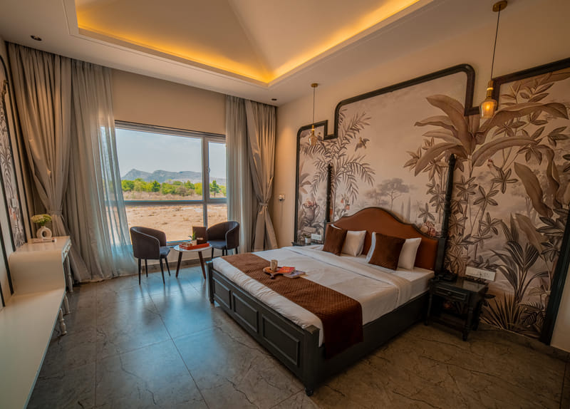 The Superior Room at Nazaara Hills Retreat, Udaipur, with its window view of the surrounding hills.
