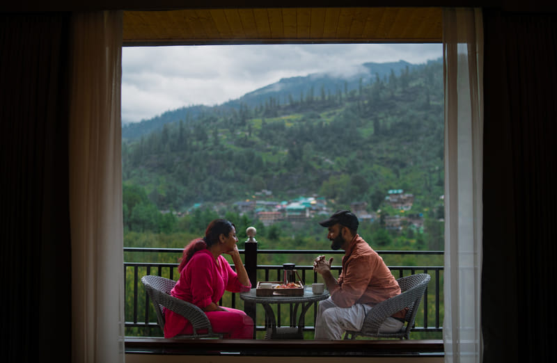 Guests in conversation over coffee on a private balcony at Nazaara Luxe Retreat