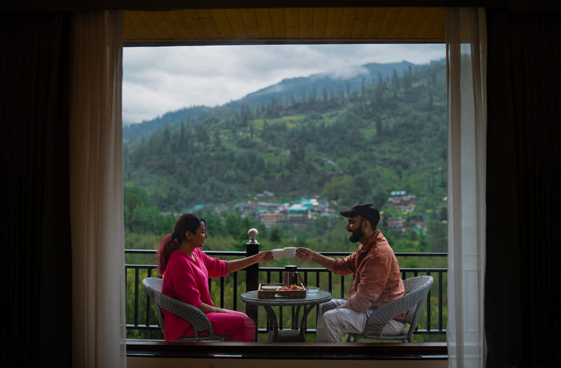 Guests sharing coffee on a private balcony at Nazaara Luxe Retreat