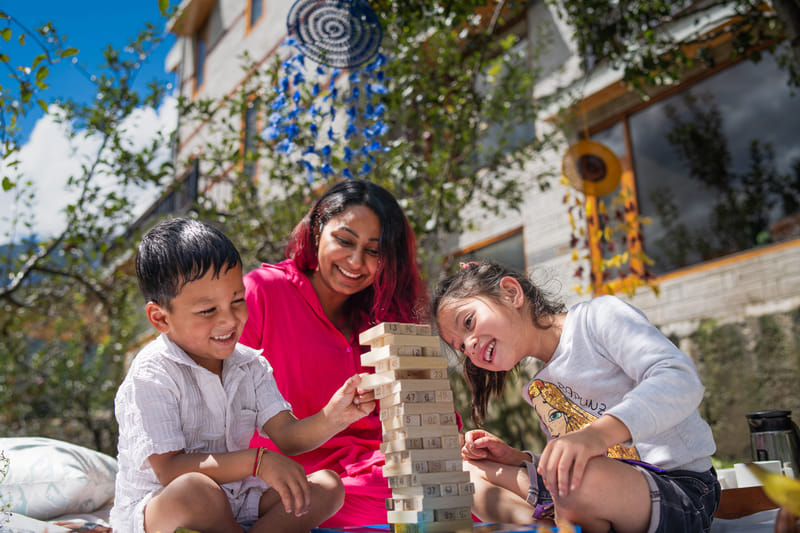 A family picnicking on the lawn at Nazaara Luxe Retreat, the building visible behind them