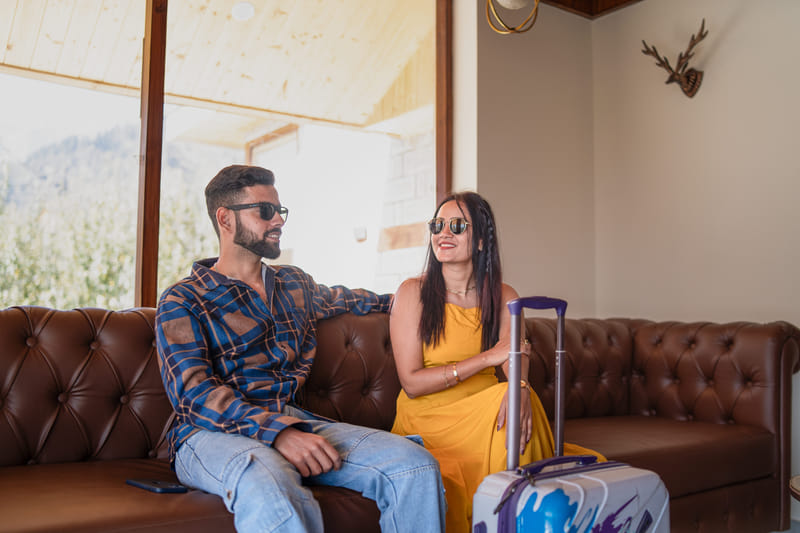 Close-up of guests seated on a cushioned couch in the lobby of Nazaara Luxe Retreat
