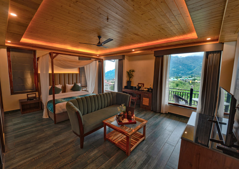 Luxurious Room bed, sofa, and work desk arranged at Nazaara Luxe Retreat