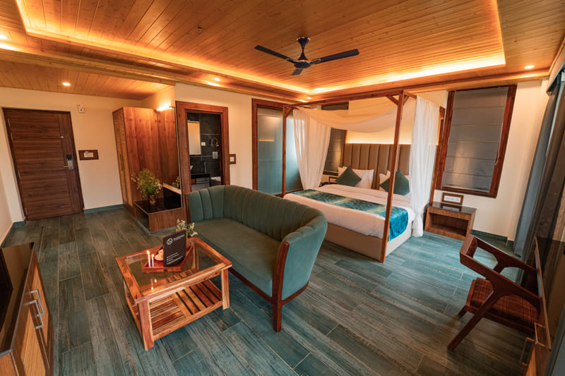 Luxurious Room sofa, canopy bed, and wardrobe arranged at Nazaara Luxe Retreat