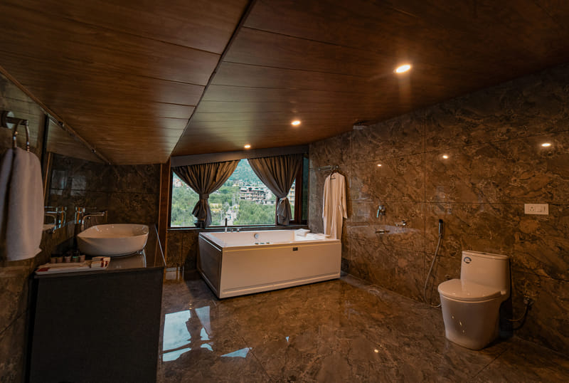 Private Jacuzzi tub in the Nazaara Luxe Duplex room, positioned beside a window with a clear mountain view