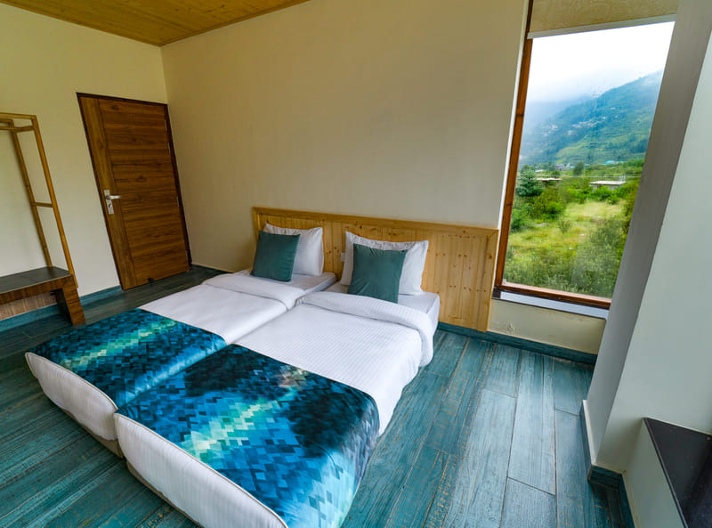 Twin beds in the second bedroom of the Nazaara Luxe Interconnected room, mountain view outside