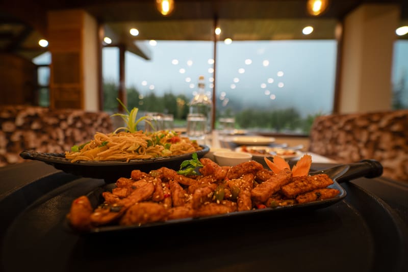 A plate of noodles and chicken served at Restro & Café, Nazaara Luxe Retreat