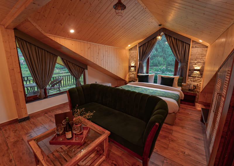 An attic-style suite corner with a sofa at Nazaara Luxe Retreat