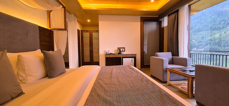 Superior Room bed, wardrobe, and armchairs arranged at Nazaara Luxe Retreat