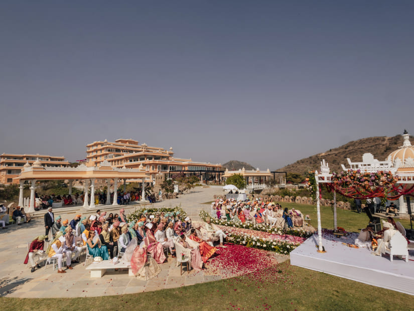 Crowd gathered in a lawn at the Fateh Vilas, Udaipur to watch the wedding rituals taking place between the bride and groom under a decorated canopy.