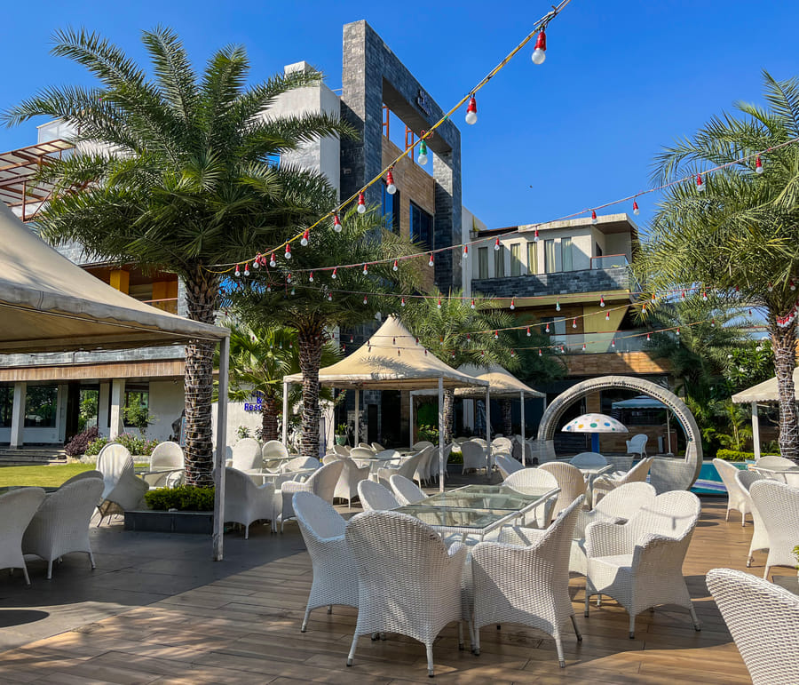 Flamingo Restaurant, poolside tables and wicker chairs beneath the festoon lights